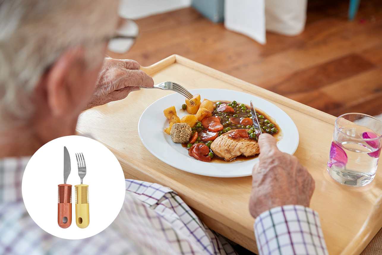 Senior isst mit ergonomischem Besteck zur Unterstützung bei eingeschränkter Handbeweglichkeit.